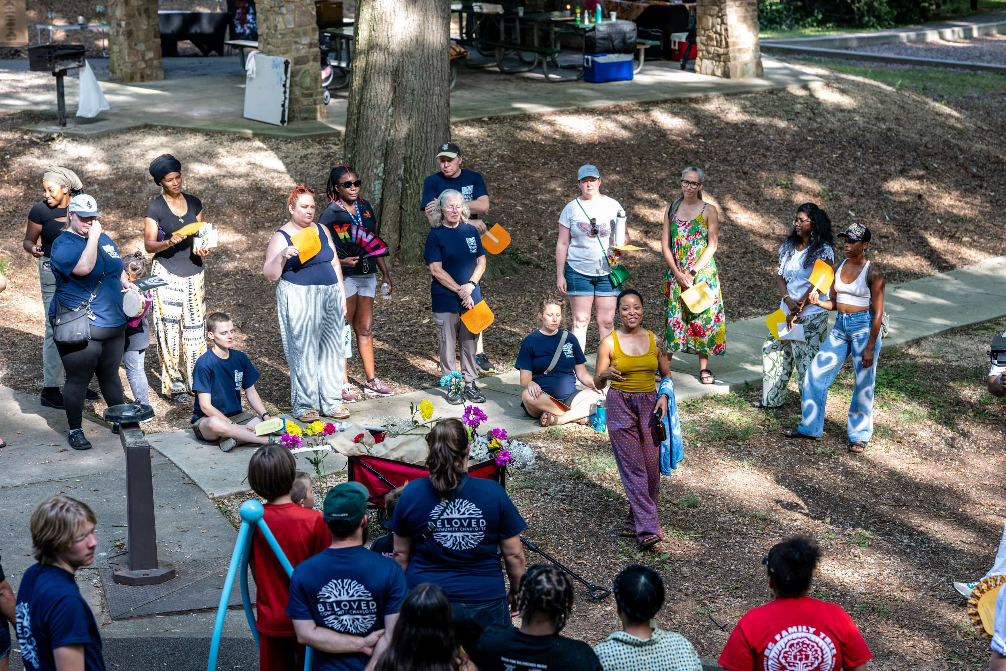 People gathered around park listening to speaker